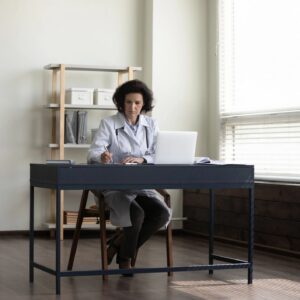 Focused serious senior head doctor working at hospital office workplace
